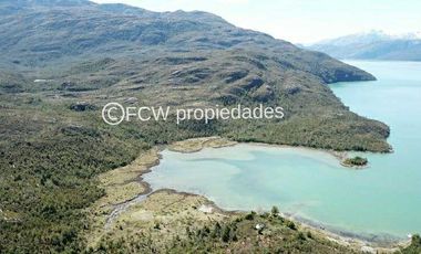 Aerial view of the land parcel showcasing the bay, surrounding forest, and a small island off the coast.