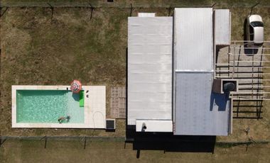 CASA DE DOS DORMITORIOS CON PISCINA Y COCHERA SEMI CUBIERTA. BARRIO PRIVADO, LAS CASUARINAS. IBARLUCEA.