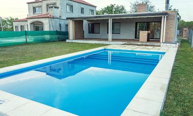 CASA DE DOS DORMITORIOS CON PISCINA Y COCHERA SEMI CUBIERTA. BARRIO PRIVADO, LAS CASUARINAS. IBARLUCEA.