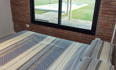 CASA DE DOS DORMITORIOS CON PISCINA Y COCHERA SEMI CUBIERTA. BARRIO PRIVADO, LAS CASUARINAS. IBARLUCEA.